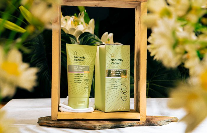 Naturally Radiant Brightening Hot Cloth Cleanser with fresh floral background.